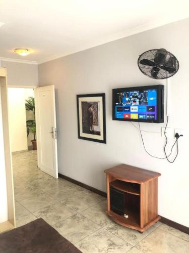 um quarto com uma televisão de ecrã plano na parede em Andrienne Lodge Cape Town na Cidade do Cabo