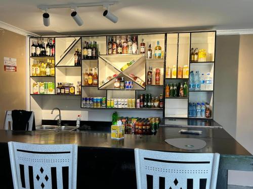 een bar met 2 stoelen en een bar met drankjes bij Meirah Gardens Naivasha in Naivasha