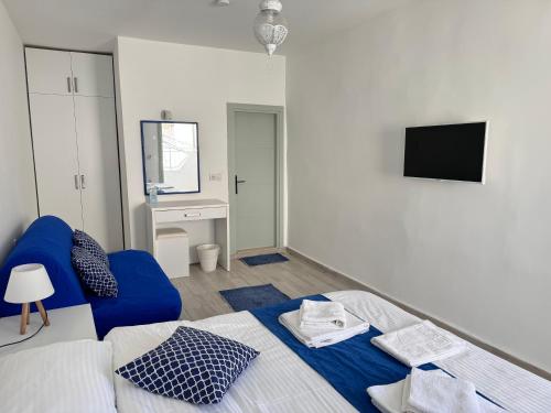a bedroom with a blue bed and a tv at White and Blue Bodrum in Bodrum City
