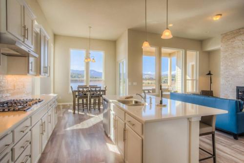 a kitchen with white cabinets and a blue couch at Luxury Lake House With Mountain Views & Hot Tub in Monument