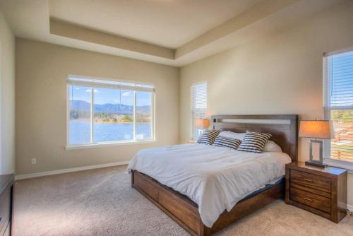 a bedroom with a bed and a large window at Luxury Lake House With Mountain Views & Hot Tub in Monument