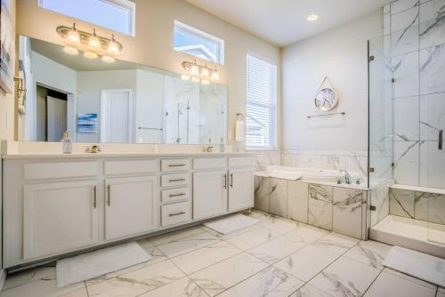 a bathroom with a tub and a sink and a shower at Luxury Lake House With Mountain Views & Hot Tub in Monument