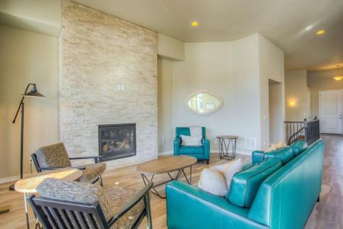 a living room with blue furniture and a fireplace at Luxury Lake House With Mountain Views & Hot Tub in Monument