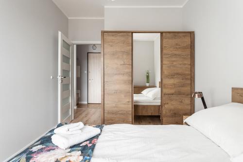 a bedroom with a large mirror next to a bed at Apartament Sucha 77 in Gdańsk