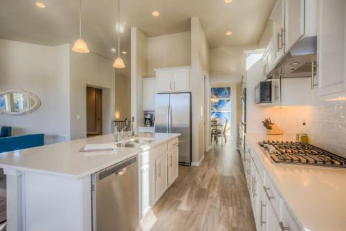 a large kitchen with white cabinets and a counter top at Luxury Lake House With Mountain Views & Hot Tub in Monument