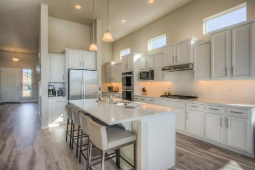a kitchen with white cabinets and a large island with bar stools at Luxury Lake House With Mountain Views & Hot Tub in Monument