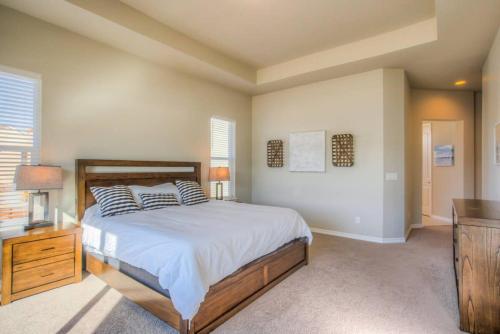 a bedroom with a bed and a dresser and window at Luxury Lake House With Mountain Views & Hot Tub in Monument