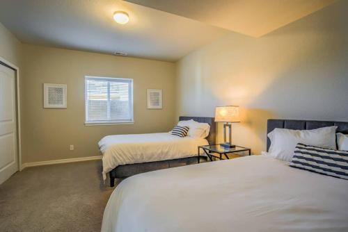 a bedroom with two beds and a window at Luxury Lake House With Mountain Views & Hot Tub in Monument