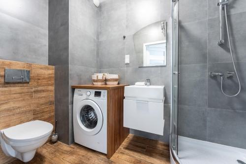 a bathroom with a washing machine and a washer at Apartament Sucha 77 in Gdańsk