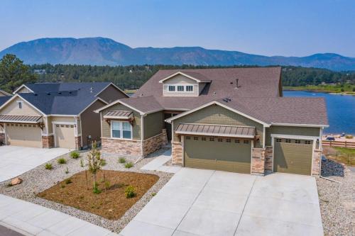 a large house with a driveway and mountains in the background at Luxury Lake House With Mountain Views & Hot Tub in Monument