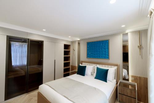 a bedroom with a large white bed with blue pillows at Holland Park Residence in London