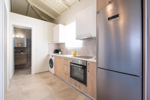 a kitchen with a stainless steel refrigerator and wooden cabinets at Cielo Home in Zipárion