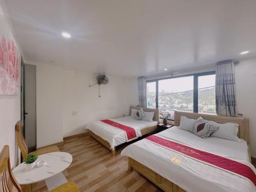 um quarto com 2 camas e uma janela em GEM HOSTEL em Ilha de Cát Bà