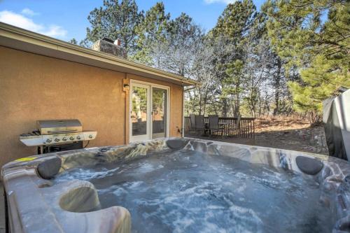 a hot tub on a patio next to a house at 4BD With Game Lounge Hot tub Dog Friendly USAFA in Pikeview