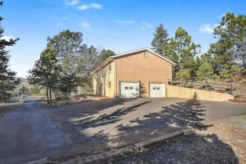 a house with a garage on the side of a road at 4BD With Game Lounge Hot tub Dog Friendly USAFA in Pikeview
