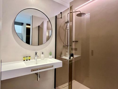 a bathroom with a sink and a mirror at Feelathome Nervión Apartments in Seville