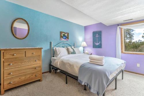 a bedroom with a bed and a dresser and a mirror at 4BD Woodland Lodge Pool Table Grill Dogs Welcome in Monument