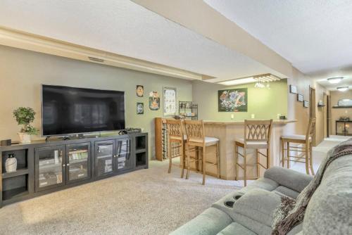 a living room with a flat screen tv and a kitchen at 4BD Woodland Lodge Pool Table Grill Dogs Welcome in Monument