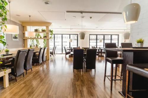 ein Esszimmer mit schwarzen Stühlen und einer Bar in der Unterkunft Hotel Sonne29 in Ebermannstadt