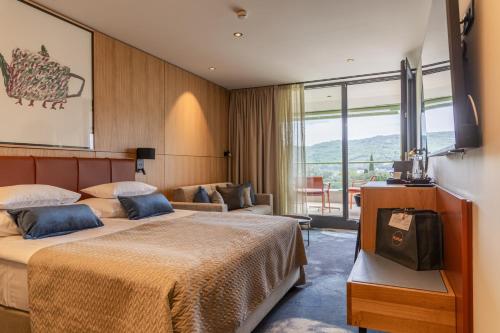 a hotel room with two beds and a balcony at Hotel Svoboda - Terme Krka in Strunjan