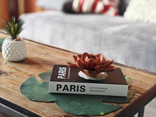 a book on a table with a flower on it at Au jardin suspendu in Vanves