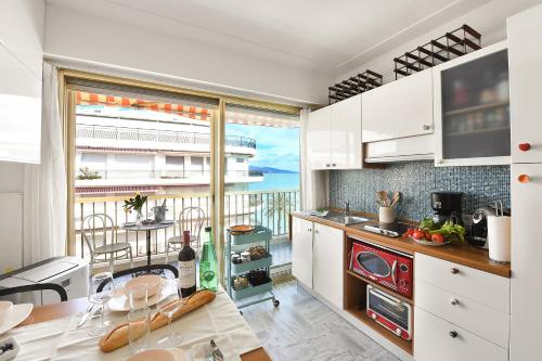 une cuisine avec des armoires blanches et une vue sur l'océan dans l'établissement Residence Cap 35 - Happy Rentals, à Roquebrune-Cap-Martin