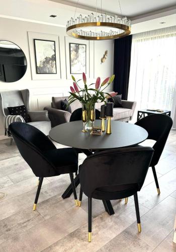 a dining room with a black table and chairs at Apartamenty BLUE BALTIC SPA Jacuzzi & Sauna MORZE in Chłopy