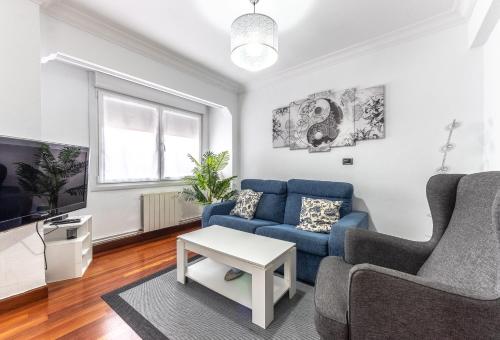 a living room with a blue couch and a tv at Portu Style by Aston Rentals in Portugalete