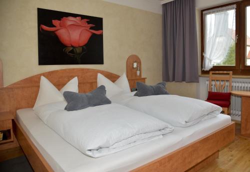 1 dormitorio con 2 camas con sábanas blancas en Pension Langerspacher, en Grabenstätt