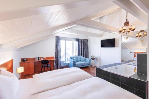 a hotel room with a bed and a bathroom at Sorell Hotel Sonnental in Dübendorf
