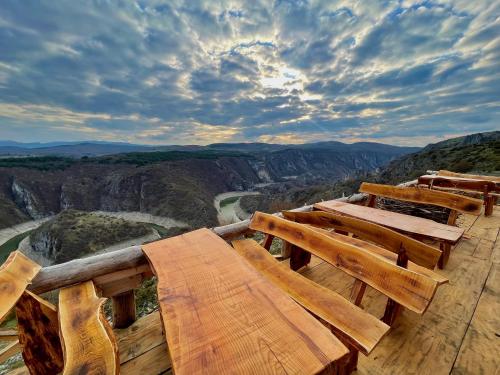 a group of wooden benches sitting on top of a mountain at Ethno village Molitva in Družiniće