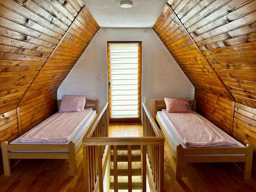 two beds in a room with a attic at Holiday Home Krajina II in Vlasic