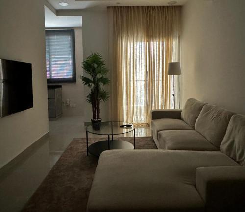 a living room with a couch and a table at Cozy Apartment in Boshar in Muscat
