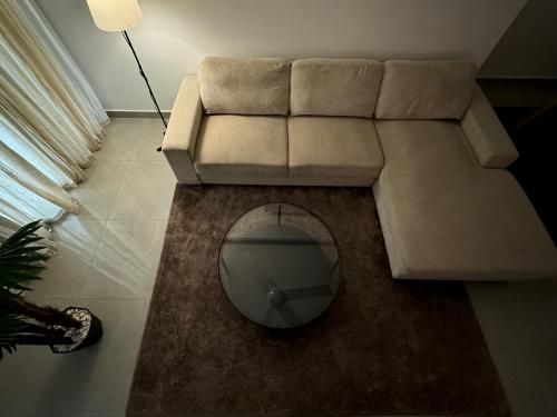 a living room with a couch and a mirror at Cozy Apartment in Boshar in Muscat