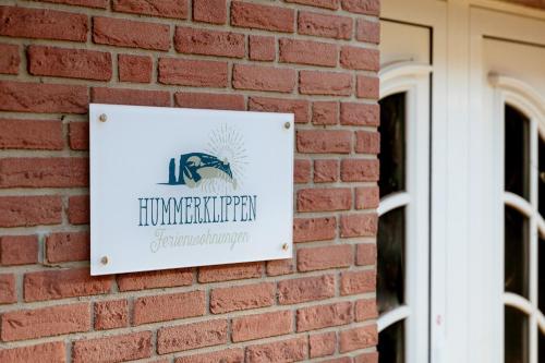 a sign on the side of a brick building at Hummerklippen Ferienwohnungen in Helgoland