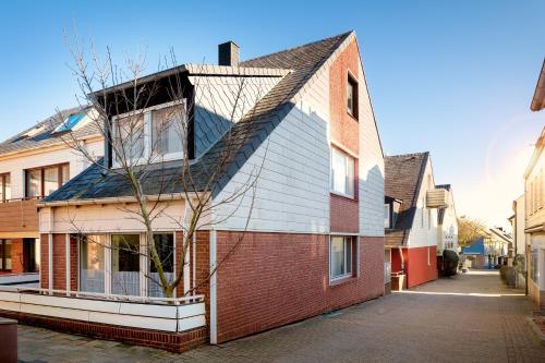 a house with a gambrel roof on a street at Hummerklippen Ferienwohnungen in Helgoland