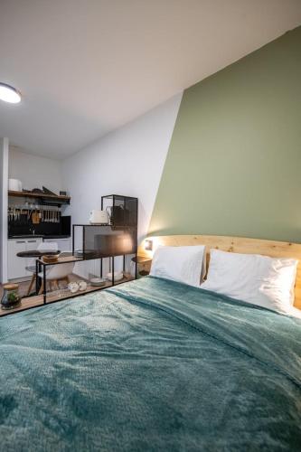 une chambre avec un grand lit avec une couverture verte dans l'établissement Suite Kella Tassin - Beau studio rénové, à Tassin-la-Demi-Lune