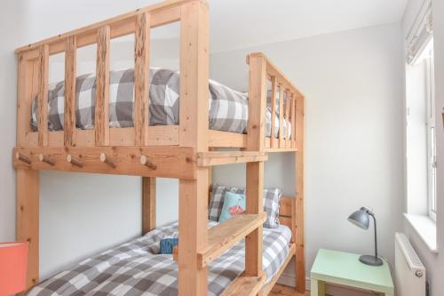 a wooden bunk bed in a small room at Blackberry Cottage in Bembridge