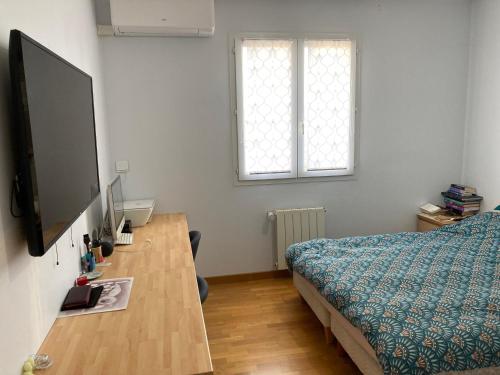1 dormitorio con 1 cama y escritorio con TV en Le Petit Paradis Lescurien, en Lescure-dʼAlbigeois