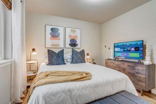 a bedroom with a large bed and a flat screen tv at Room to Spread Out & Deck with Mountain Views in Monument