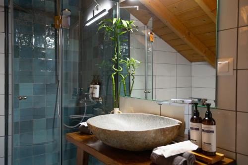 a bathroom with a large stone sink and a glass shower at The Hidden Attique in Corfu Town