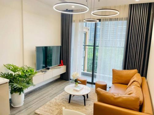 uma sala de estar com um sofá e uma televisão em 1 phòng ngủ Ruby cao cấp R105 em Gia Lâm Pho