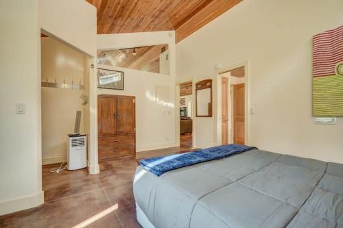 a bedroom with a large bed and a wooden ceiling at Green Mt Getaway Hot Tub Game Room & Fire Pit in Cascade-Chipita Park