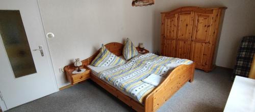 a bedroom with a wooden bed and a wooden cabinet at Ferienwohnung Katharina II in Alf