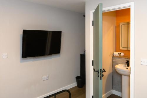 a bathroom with a flat screen tv on the wall at Gad Suite by Koya Homes - Cardiff City Centre Location!! 2 En-suites in Cardiff