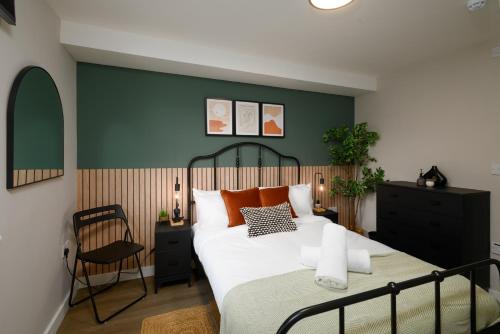 een slaapkamer met een groot bed en een stoel bij Gad Suite by Koya Homes - Cardiff City Centre Location!! 2 En-suites in Cardiff