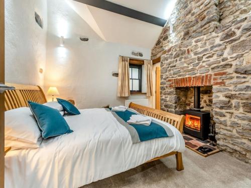 a bedroom with a bed and a stone wall at Blacksmiths Cottage in Pembroke