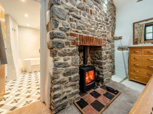 - Baño con chimenea y pared de piedra en Blacksmiths Cottage, en Pembroke