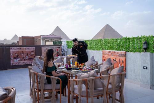 un hombre y una mujer sentados en una mesa en un patio en King of Pharaohs INN pyramids en El Cairo