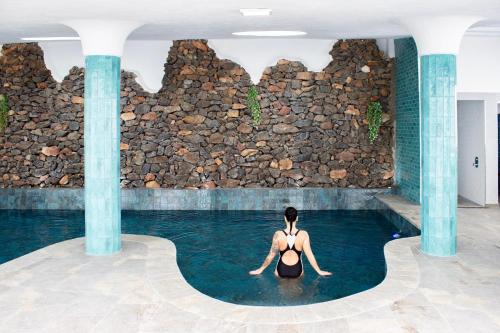 a woman is sitting in a swimming pool at Gaviotas Beach Golf in Almerimar